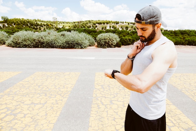 Free photo male athlete looking at smart watch