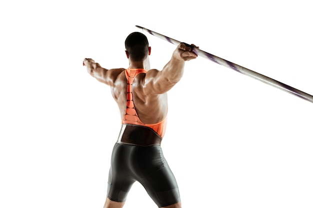 Male athlete practicing in throwing javelin on white studio.