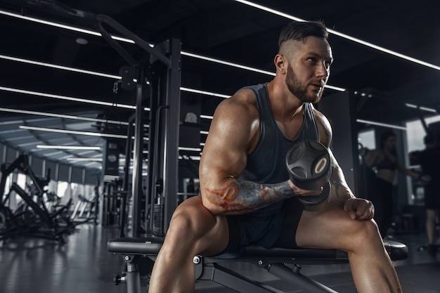 The male athlete training hard in the gym