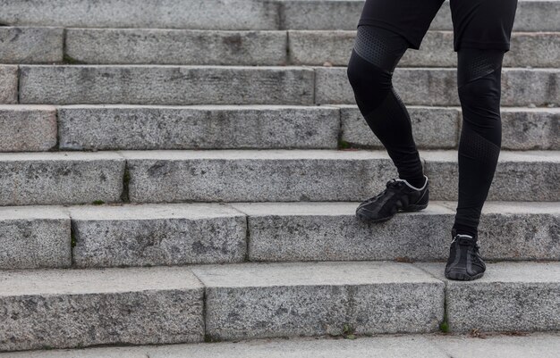 Male athletic legs walking on stairs