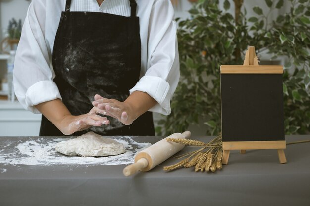 Male baker prepares bread with flour