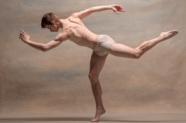 Танцор балета позирует над серым пространством