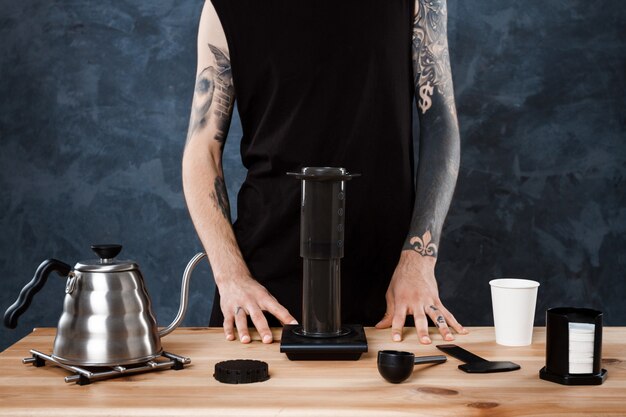 Male barista brewing coffee. Alternative method aeropress.