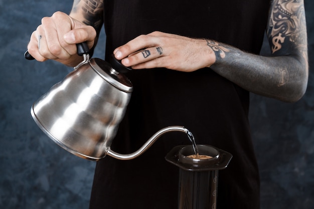 Free photo male barista brewing coffee. alternative method aeropress.