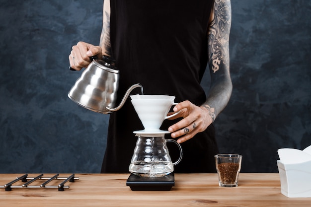 Male barista brewing coffee. Alternative method pour over.