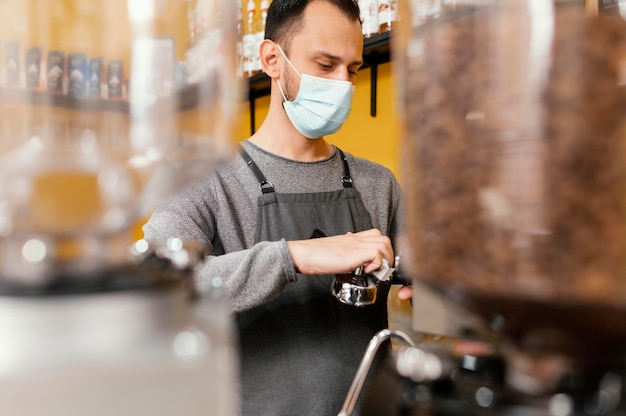 Free photo male barista cleaning professional coffee machine