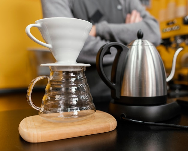 Male barista preparing coffee with kettle and filter