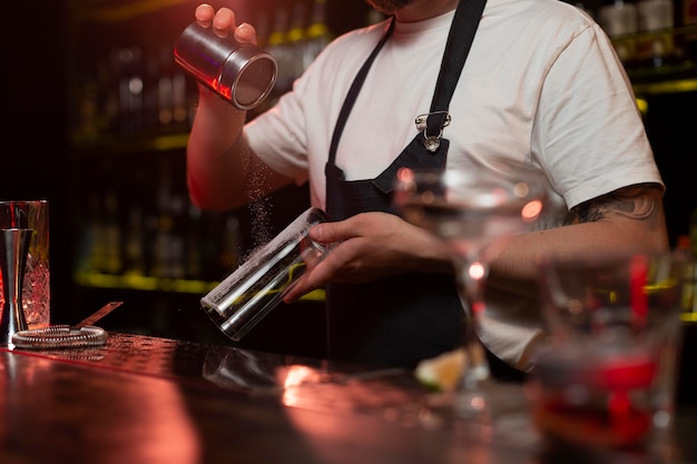 Male bartender making a cocktail with a shaker