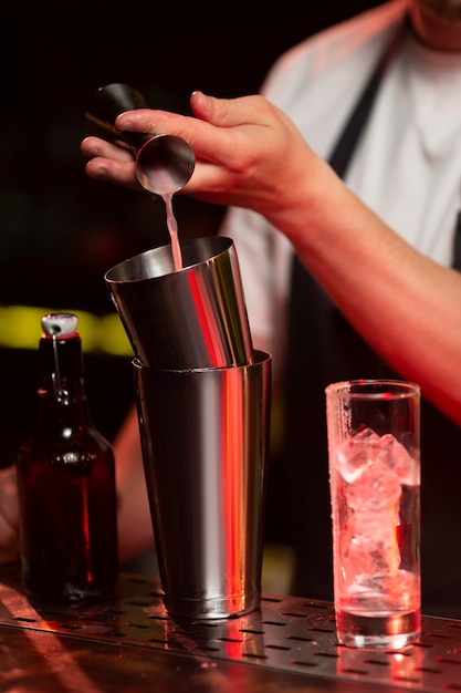 Male bartender making a cocktail with a shaker