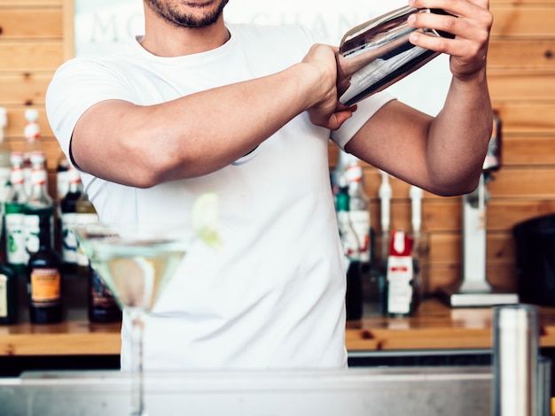 Foto gratuita barista maschio che mescola bevanda in agitatore