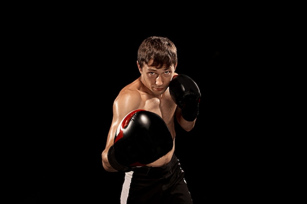 Male boxer boxing on black