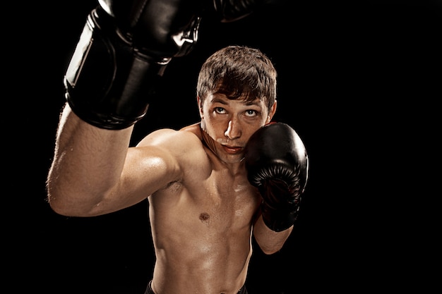 Male boxer boxing in punching bag with dramatic edgy lighting