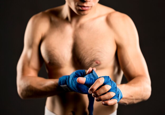 Male boxer putting on protection for hands