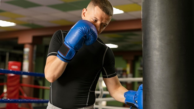 リングでトレーニングしている手袋を持つ男性ボクサー