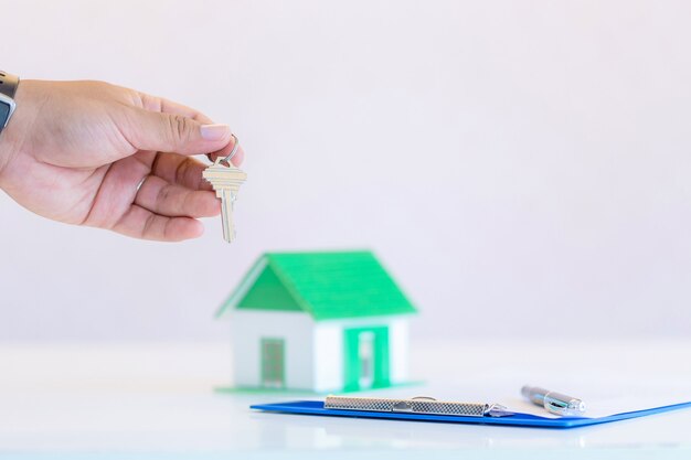 Male businessman holding, giving house keys, close-up of hand, indoor