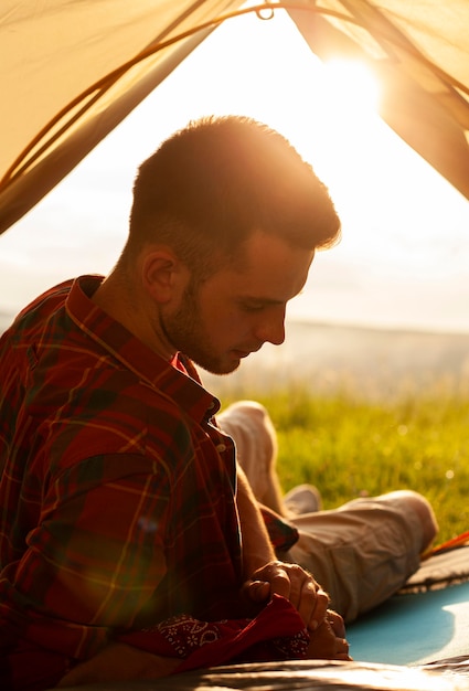 Male in camping tent at sunset