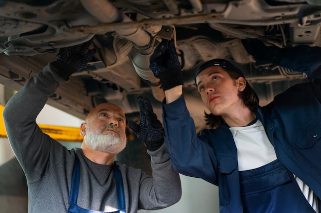 Foto gratuita meccanico di automobile maschio che lavora nell'officina di riparazione dell'automobile