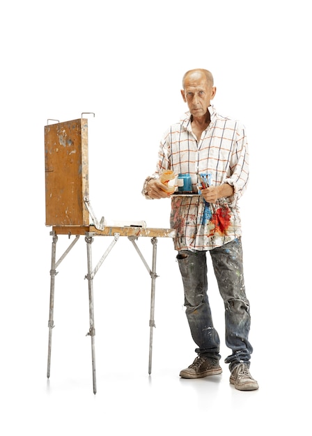 男性白人アーティスト、白いスタジオで隔離の仕事で画家