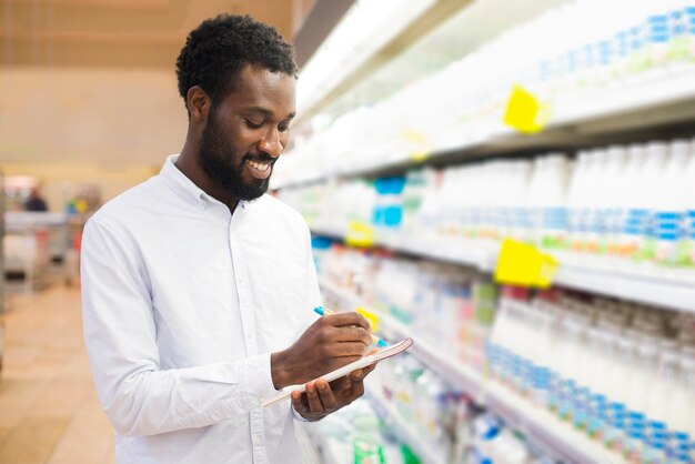 Male checking off items in grocery list