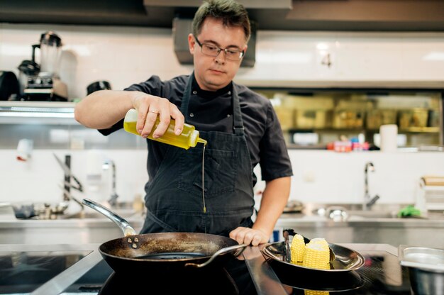 Male chef adding oil in pan