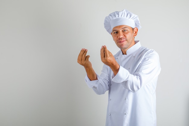 Male chef cook in hat and uniform doing italian gesture with fingers