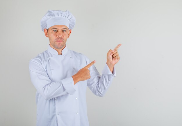 남자 요리사 요리사 모자와 유니폼 뭔가 손가락을 가리키는 자신감을 찾고