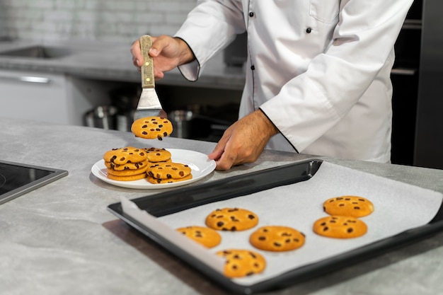 Free photo male chef in the kitchen baking cookies