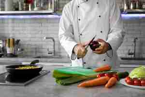 Free photo male chef in the kitchen chopping vegetables for dish