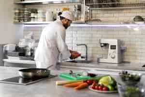 Foto gratuita cuoco unico maschio in cucina che cucina il piatto in una padella