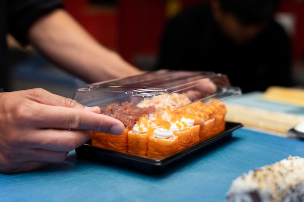 Male chef preparing a sushi order for a takeaway