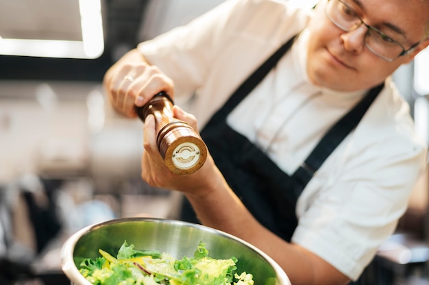 Foto gratuita insalata di condimento chef maschio