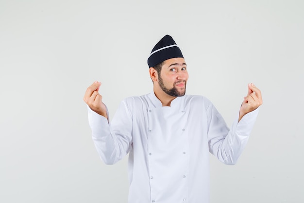 Male chef in white uniform showing meditation gesture and looking relaxed , front view.