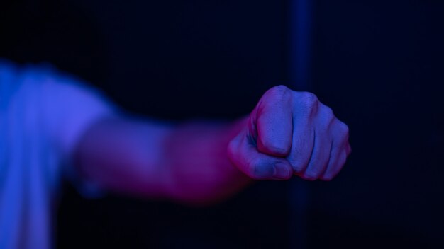 Male clenched fist on a blurred wall. Working out impact and strength.