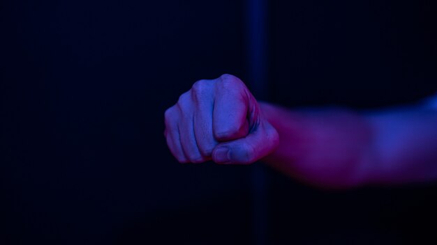 Male clenched fist on a blurred wall.