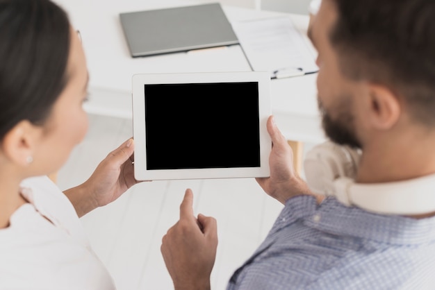 Male colleague showing tablet to female colleague