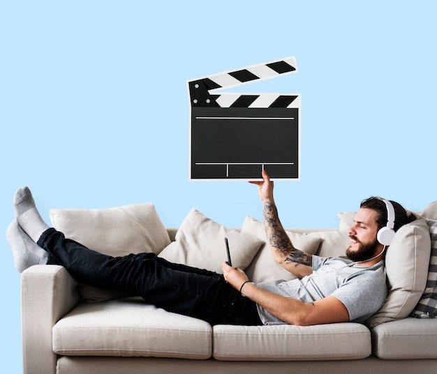 Free photo male on a couch holding a clapper icon