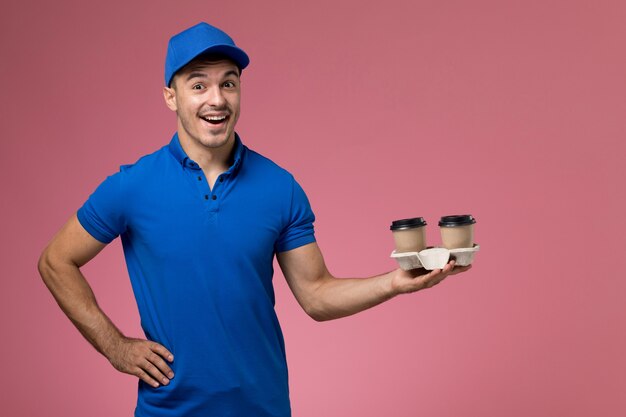 ピンクの制服サービス提供労働者にコーヒーカップを保持している青い制服の男性宅配便