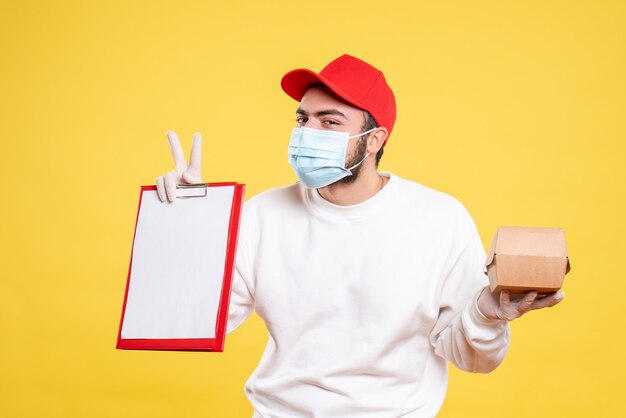 male courier in mask holding file note and little food package on yellow