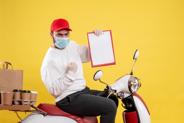 male courier in mask holding file note on yellow