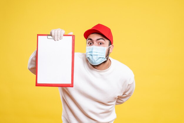 male courier in mask holding file note on yellow