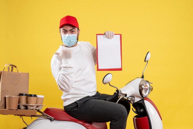 male courier in mask holding file note on yellow