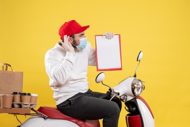 Free Photo male courier in mask holding file note on yellow
