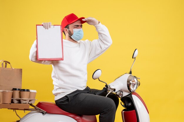 male courier in mask holding file note on yellow