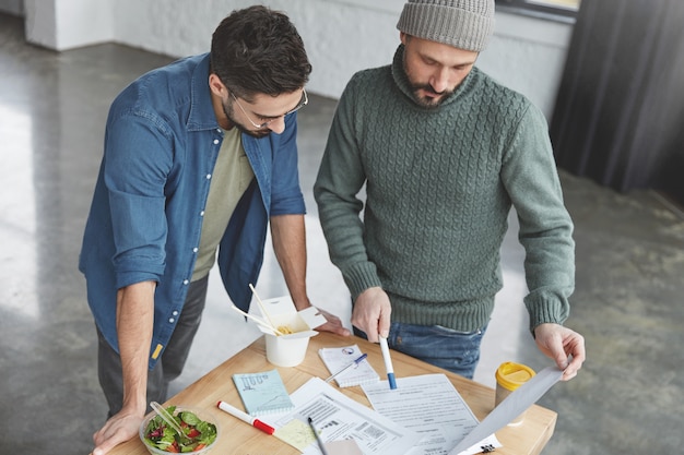 Male coworkers in office with lunch