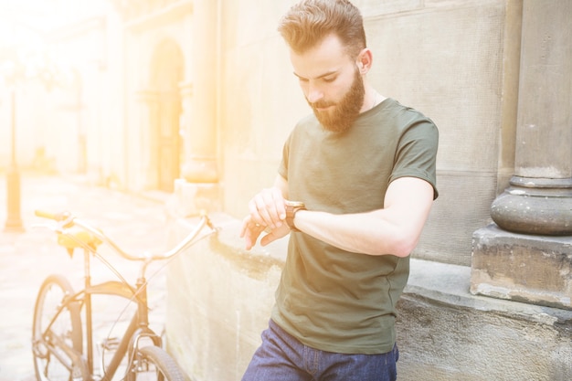 Free photo male cyclist looking at time on wrist watch