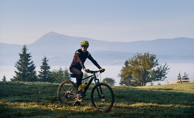 Male cyclist riding bicycle in mountains