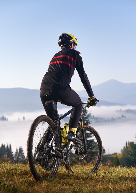 Male cyclist riding bicycle in mountains