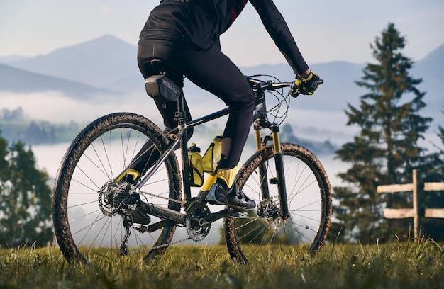 Male cyclist riding bicycle in mountains