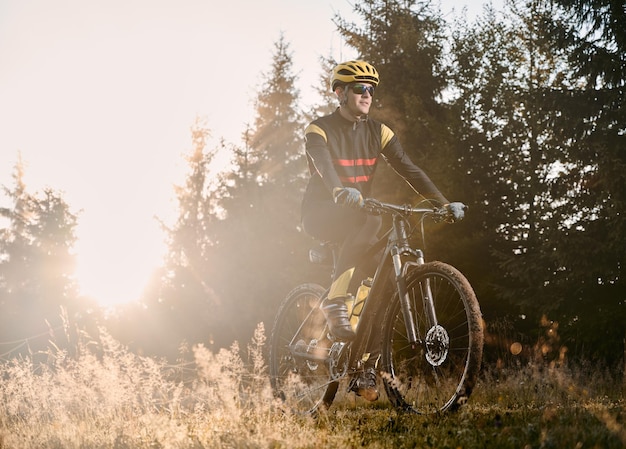 Бесплатное фото Мужчина-велосипедист на горном велосипеде в солнечный день