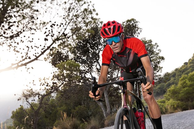 Male cyclist training with bicycle outdoors